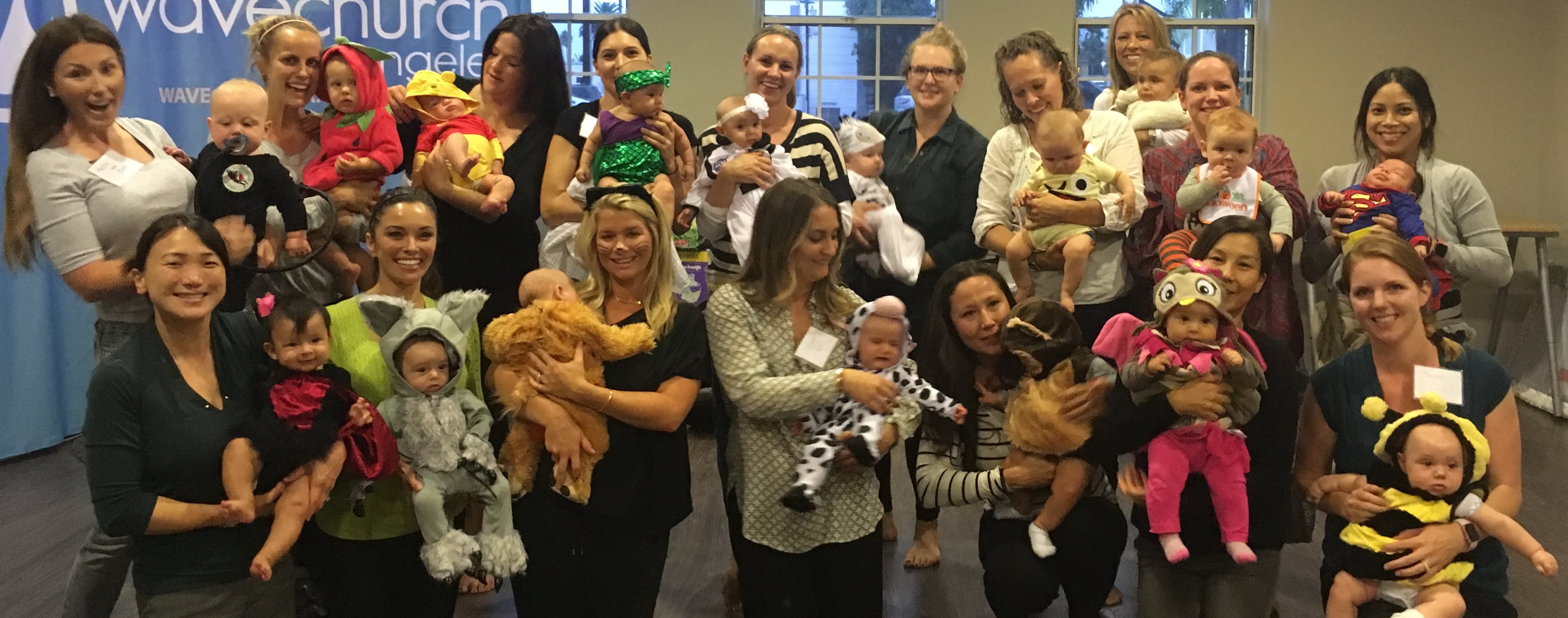 Group of moms and babies at a past Mommy and Me class celebration